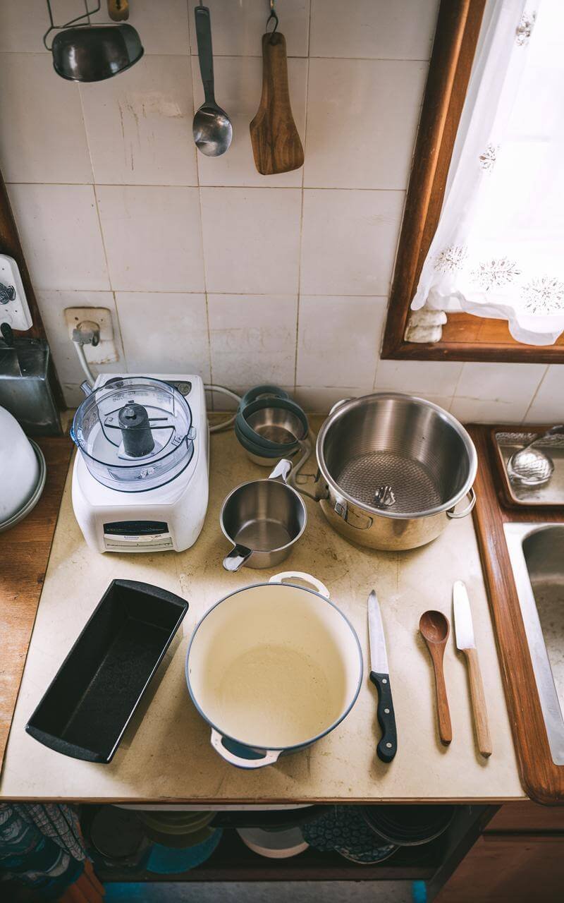 Lentil And Mushroom Loaf: A Hearty Vegan Delight 4 Overhead view of a well-equipped kitchen counter with food processor, mixing bowl, loaf pan, and measuring cups neatly arranged