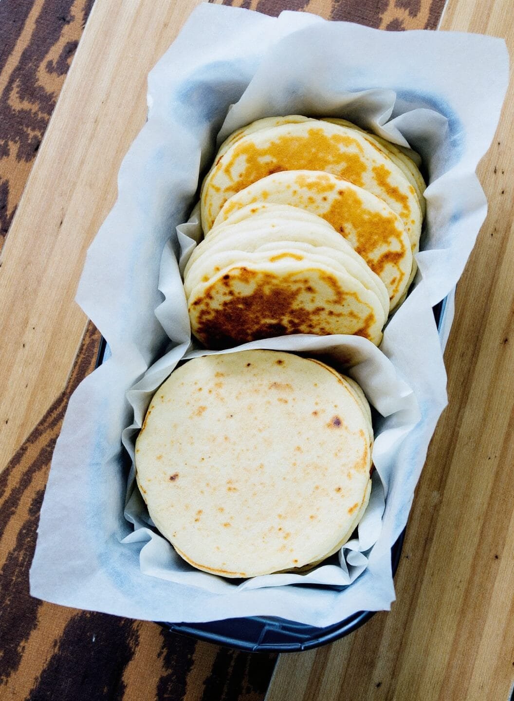 Fluffy Keto Pancakes (Almond &Amp; Coconut Flour) 7 Stacked pancakes separated by parchment paper in a meal prep storage container.