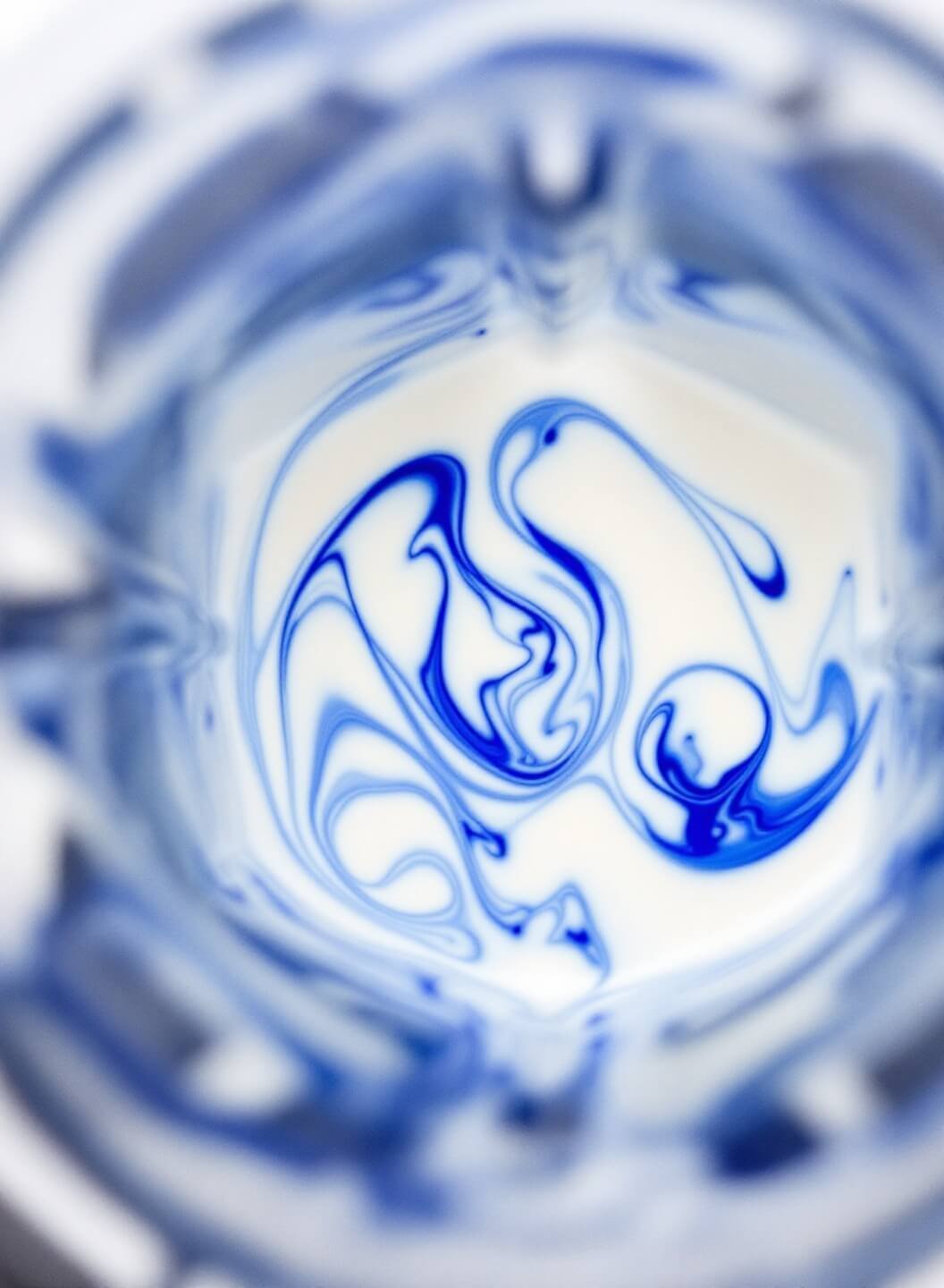 Blue Milkshake Recipe 4 Modern blender in action mixing vanilla ice cream, milk and blue food coloring, creating mesmerizing marble patterns