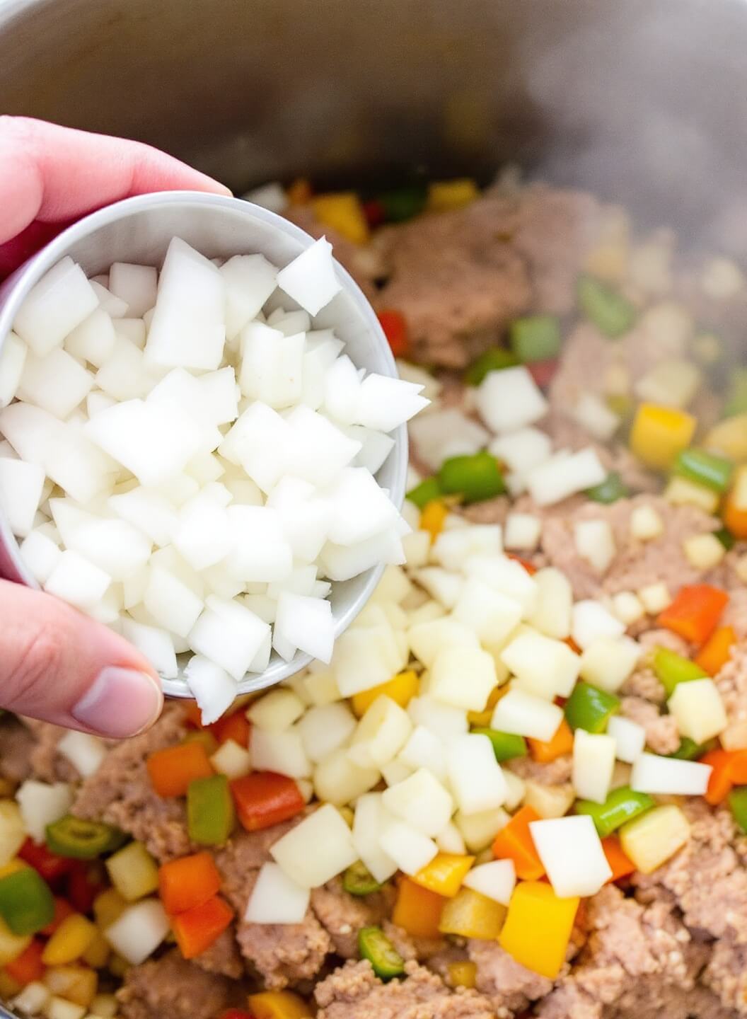 Weight Watchers Taco Soup 5 Adding diced onions, bell peppers, and minced garlic to browned turkey in a pot with steam rising as vegetables soften and become translucent