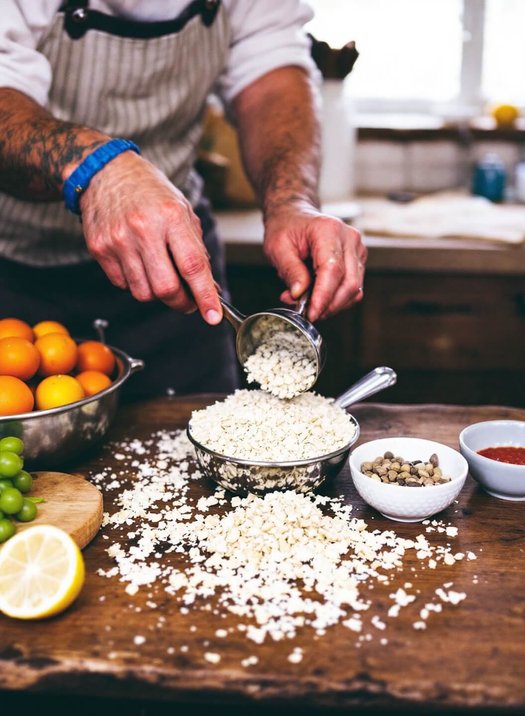 Classic Banana Bread Recipe (That Never Fails!) 5 Person folding dry ingredients into a bowl in a rustic-style kitchen