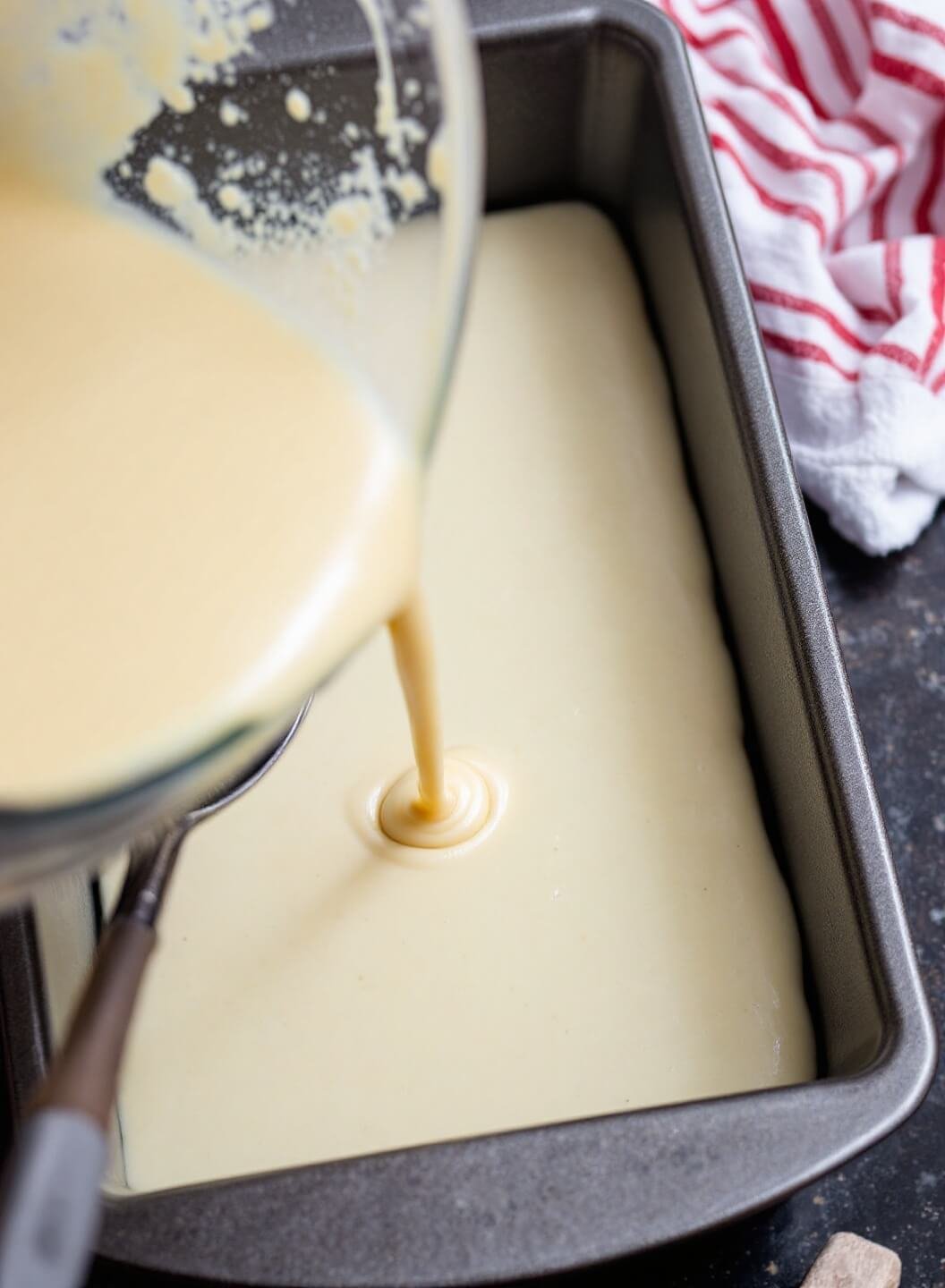 Classic Banana Bread Recipe (That Never Fails!) 6 Pouring batter into a lined loaf pan for baking preparation