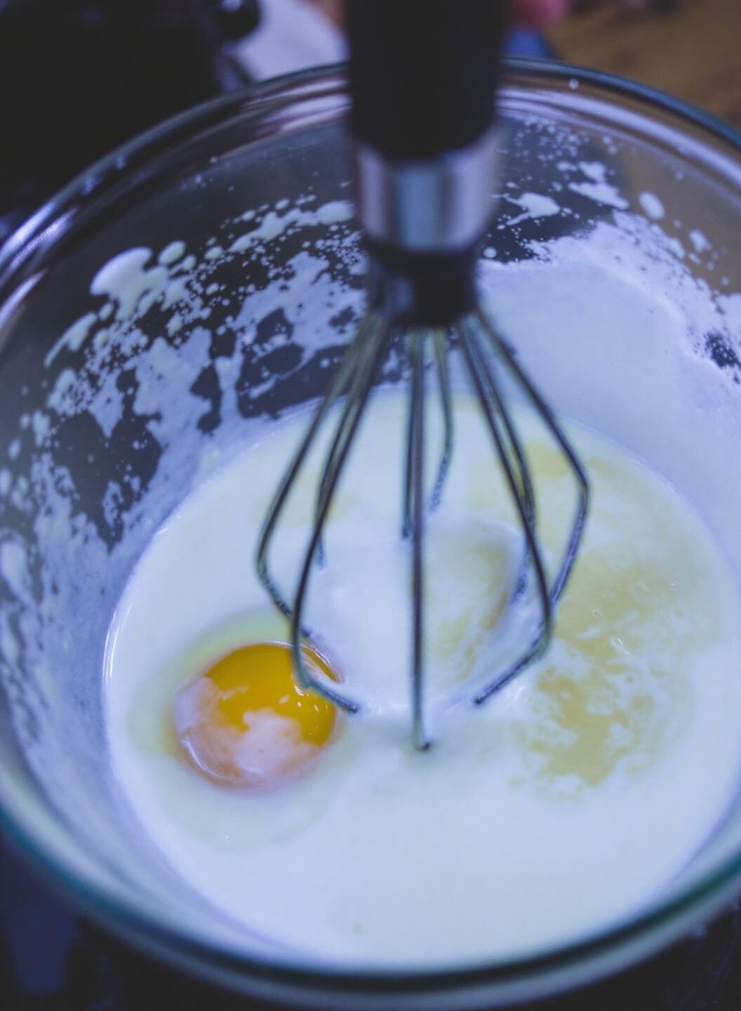 Whisking eggs, almond milk, and vanilla in a bowl for wet ingredients preparation