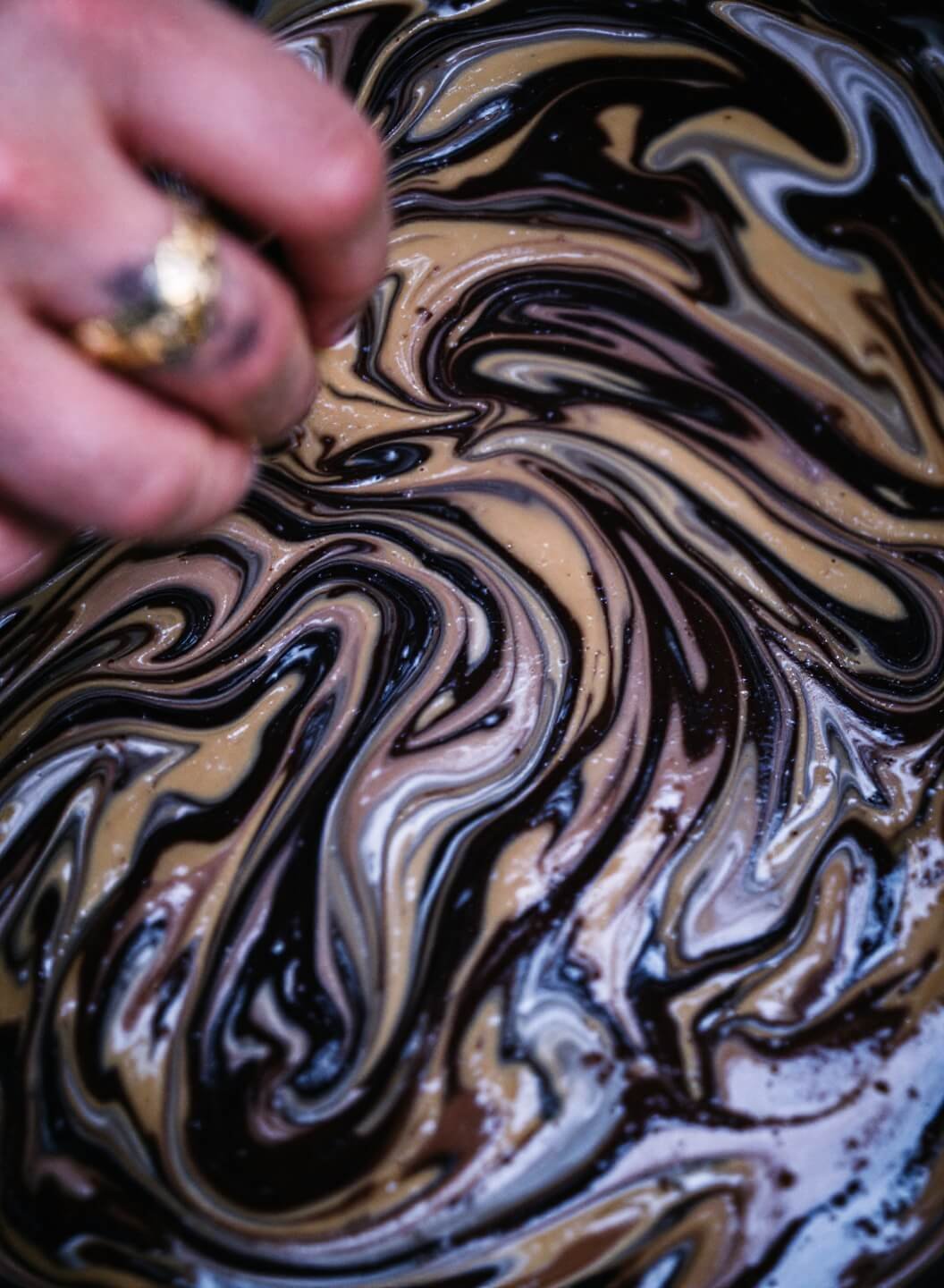 Mixing thick chocolate chip batter with a marbled texture