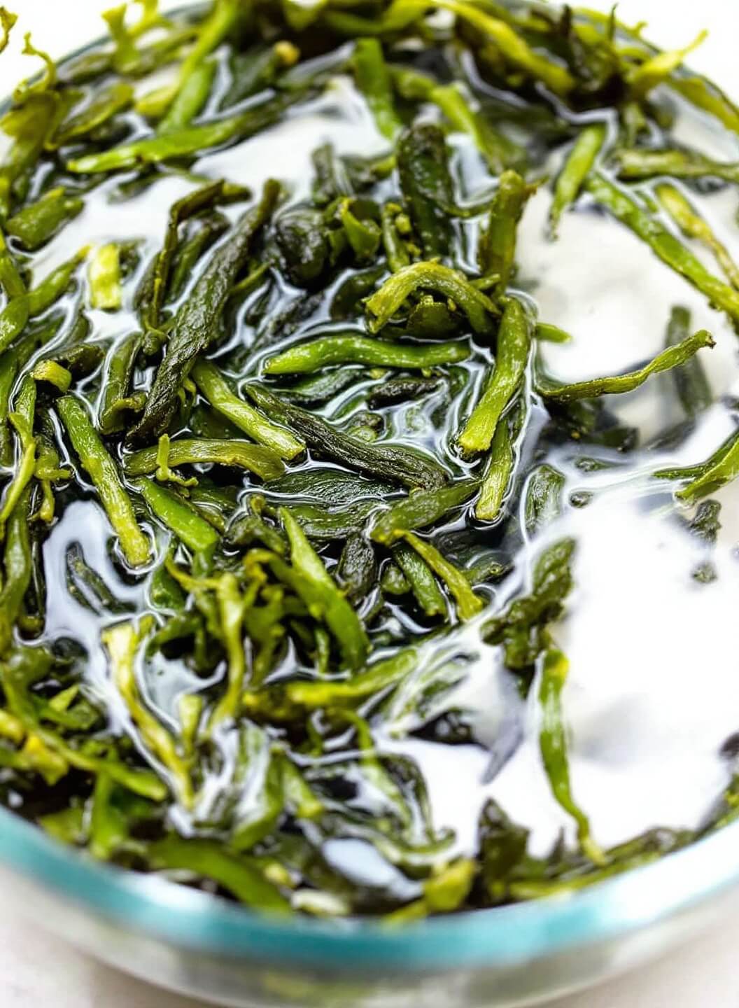 Easy Authentic Miso Soup With Tofu (Ready In 20 Minutes!) 3 Dried wakame seaweed rehydrating in a clear glass bowl of cold water, expanding and floating or settling at the bottom