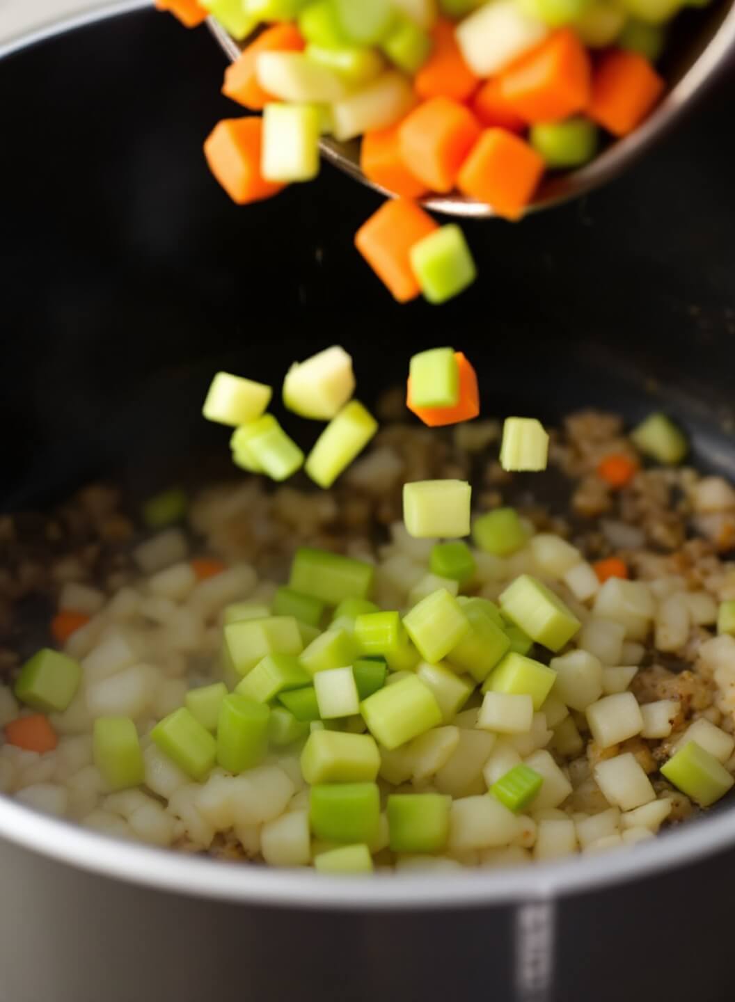 Hearty Mung Bean Soup (Vegan-Friendly) 5 Diced celery and carrots falling into a pot with sautéed onions