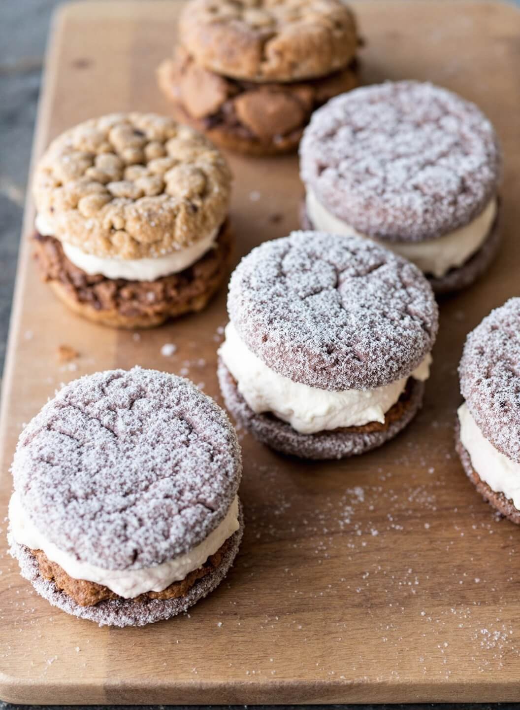Keto ice cream sandwich bars arranged on a rustic wooden board with visible frost.