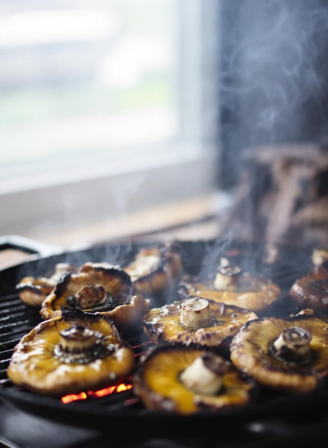 The Perfect Bunless Burger 4 Grilling portobello mushrooms with smoke rising and olive oil glistening