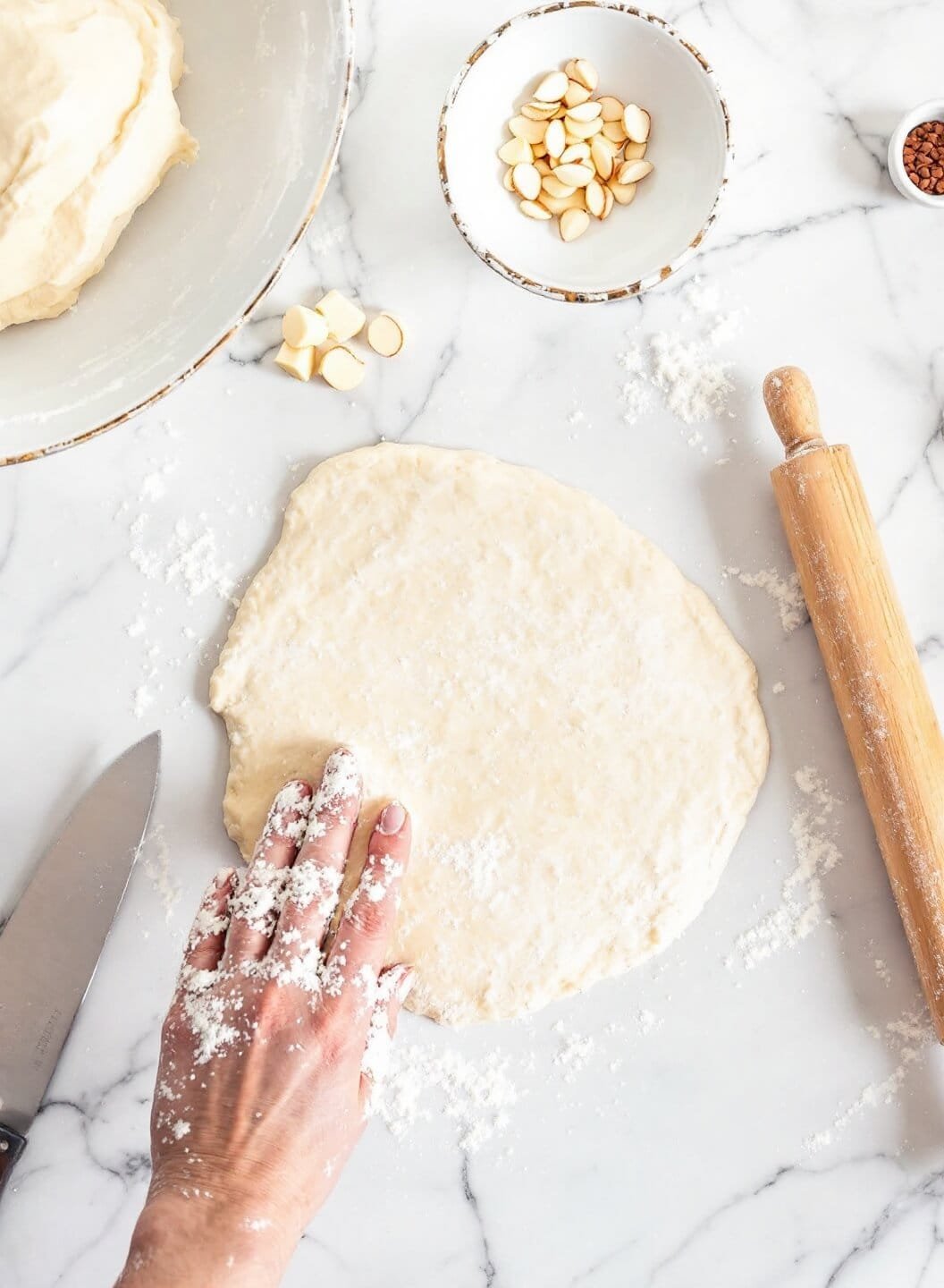 Keto Classic Apple Pie With Chayote Squash (Sugar-Free, Gluten-Free) 4 Almond flour dough being prepared on a marble counter with a rolling pin and parchment paper.