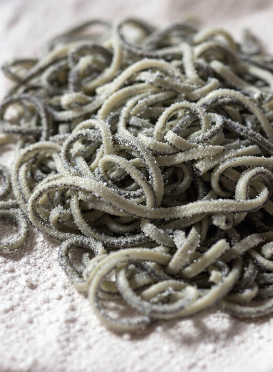 Creamy Keto Pesto Zucchini Noodles (Zoodles) 4 Close-up view of zoodles on a paper towel sprinkled with salt to draw out moisture, under natural light