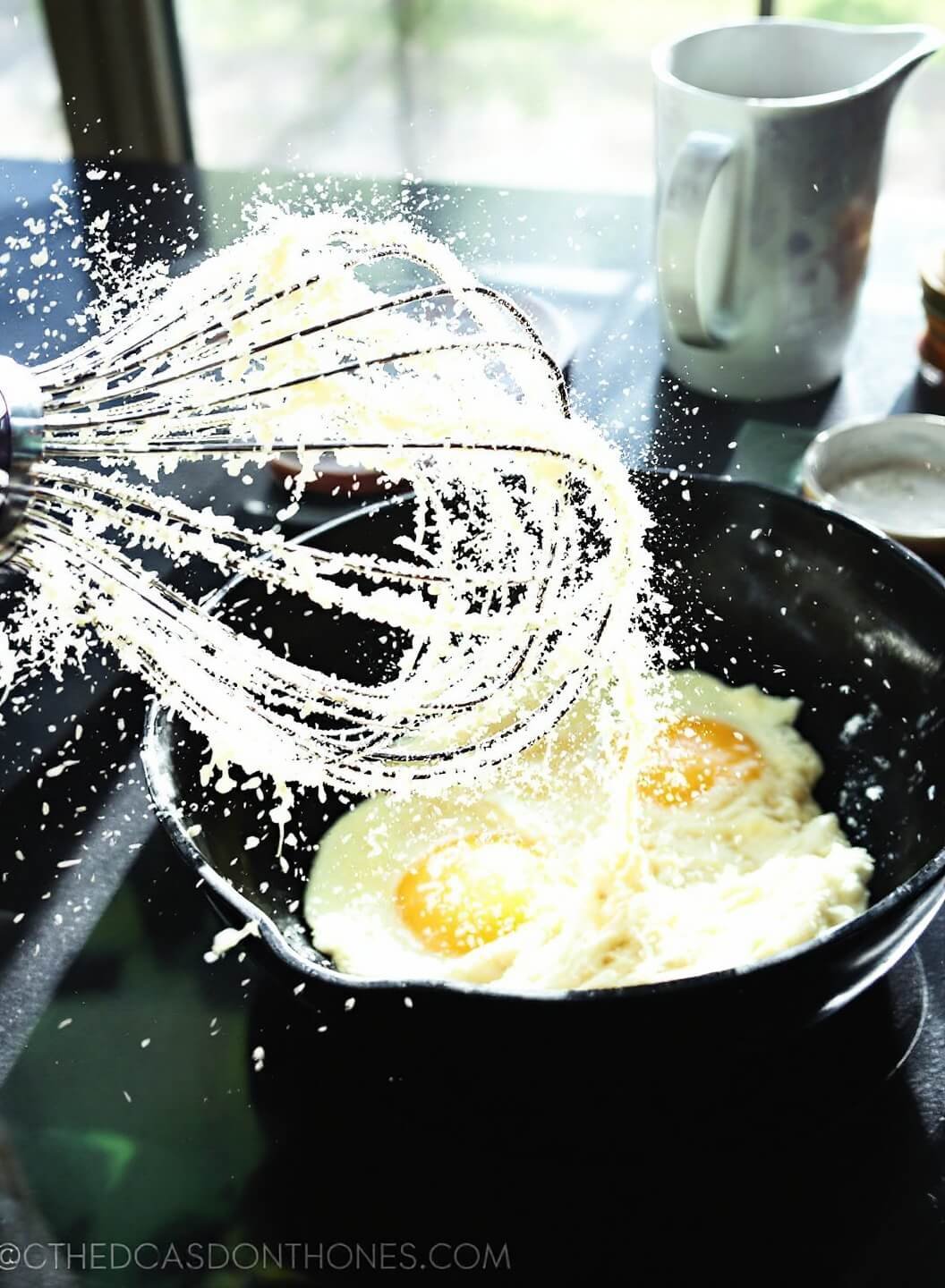 Best Ever Keto Pancakes: Fluffy, Low-Carb Breakfast Perfection 4 Fluffy beaten eggs in a bowl with a copper whisk, illuminated by morning sunlight streaming in