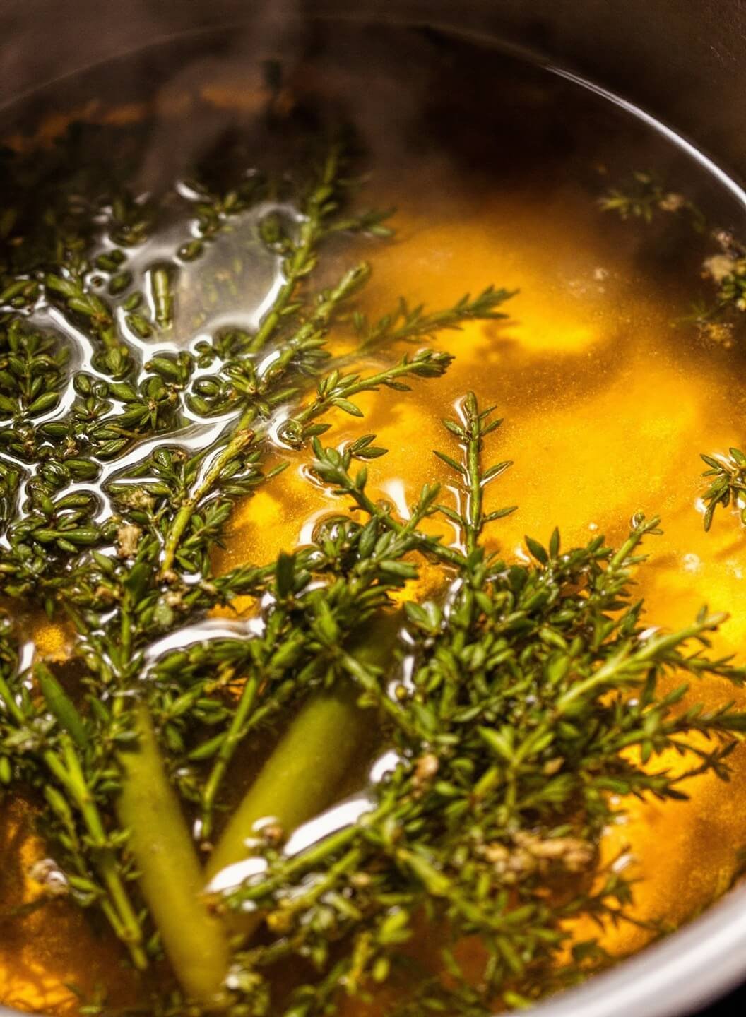 Homemade Low-Carb Chicken Noodle Soup With Shirataki/Zoodles 5 Simmering golden broth with floating herbs