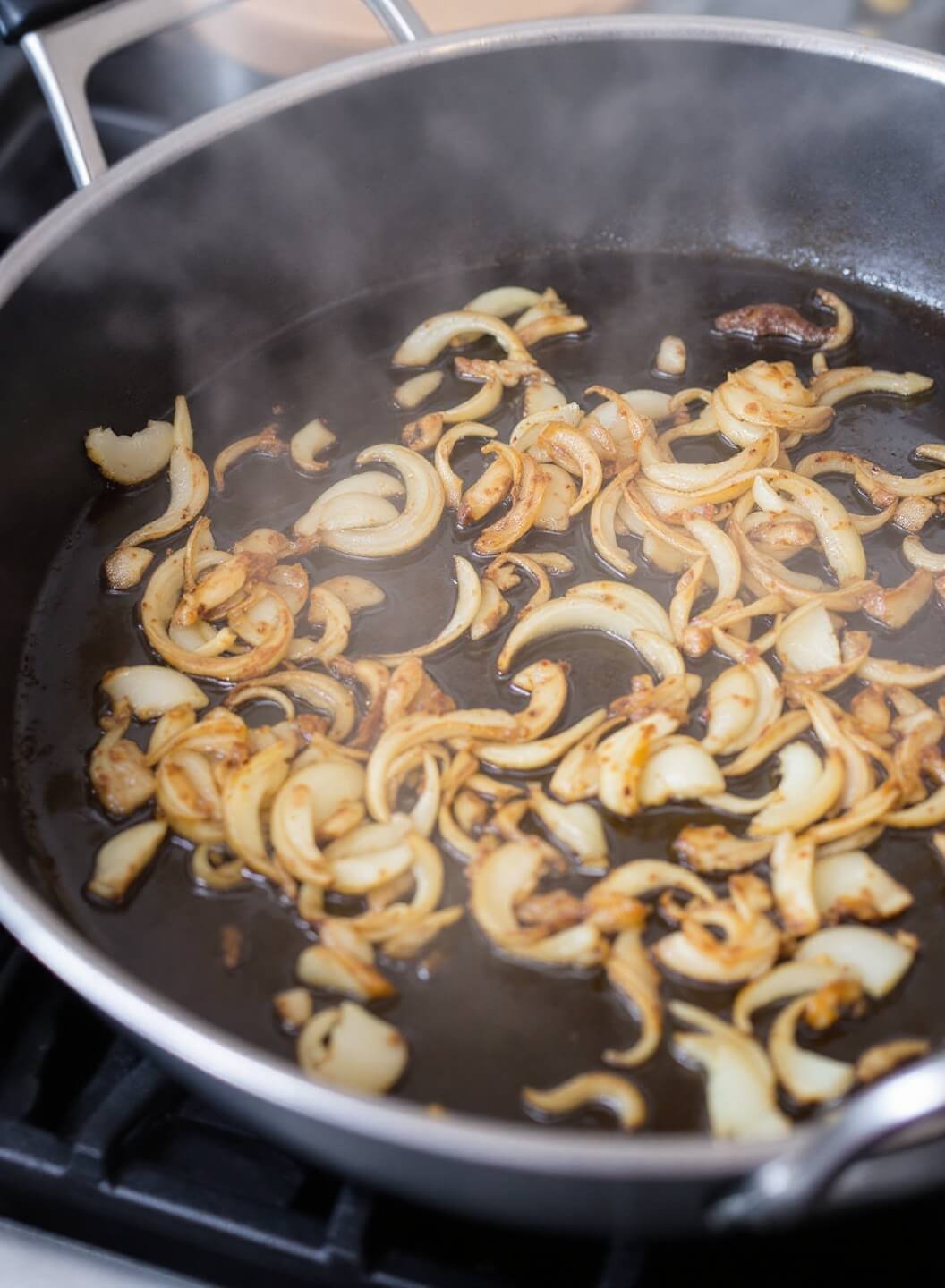 Classic French Onion Soup (Without Bread) 4 Caramelizing onions in a dutch oven with golden brown color and steam rising