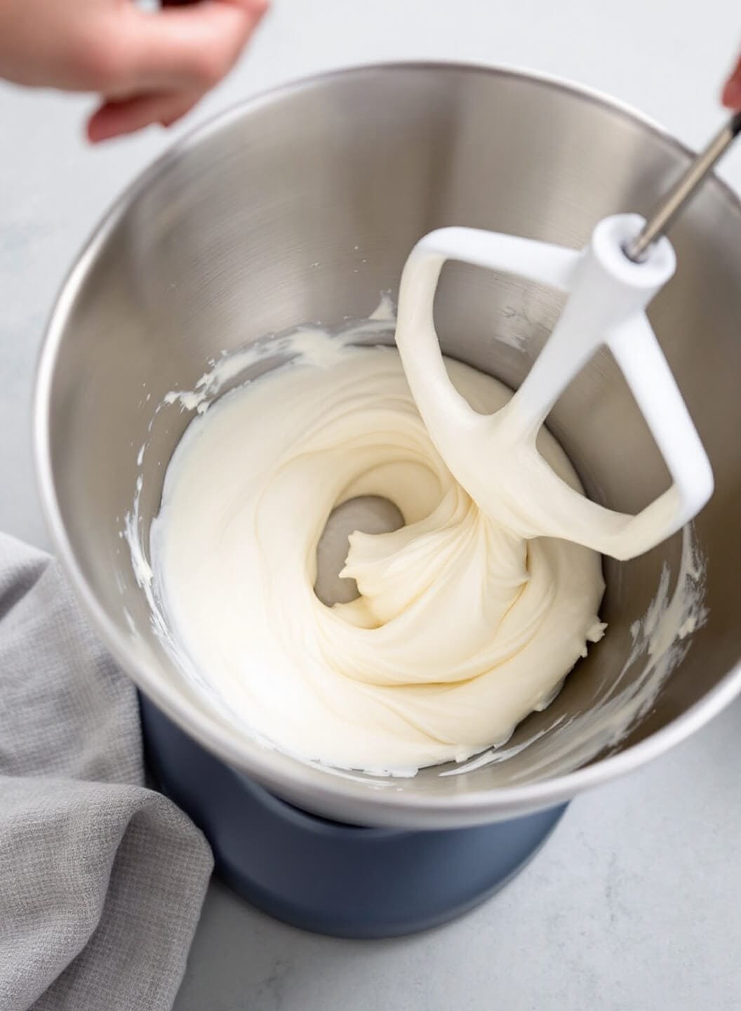 Keto New York Cheesecake With Almond Flour Crust 4 Professional kitchen setup with smooth white cream cheese being mixed in a stainless steel bowl