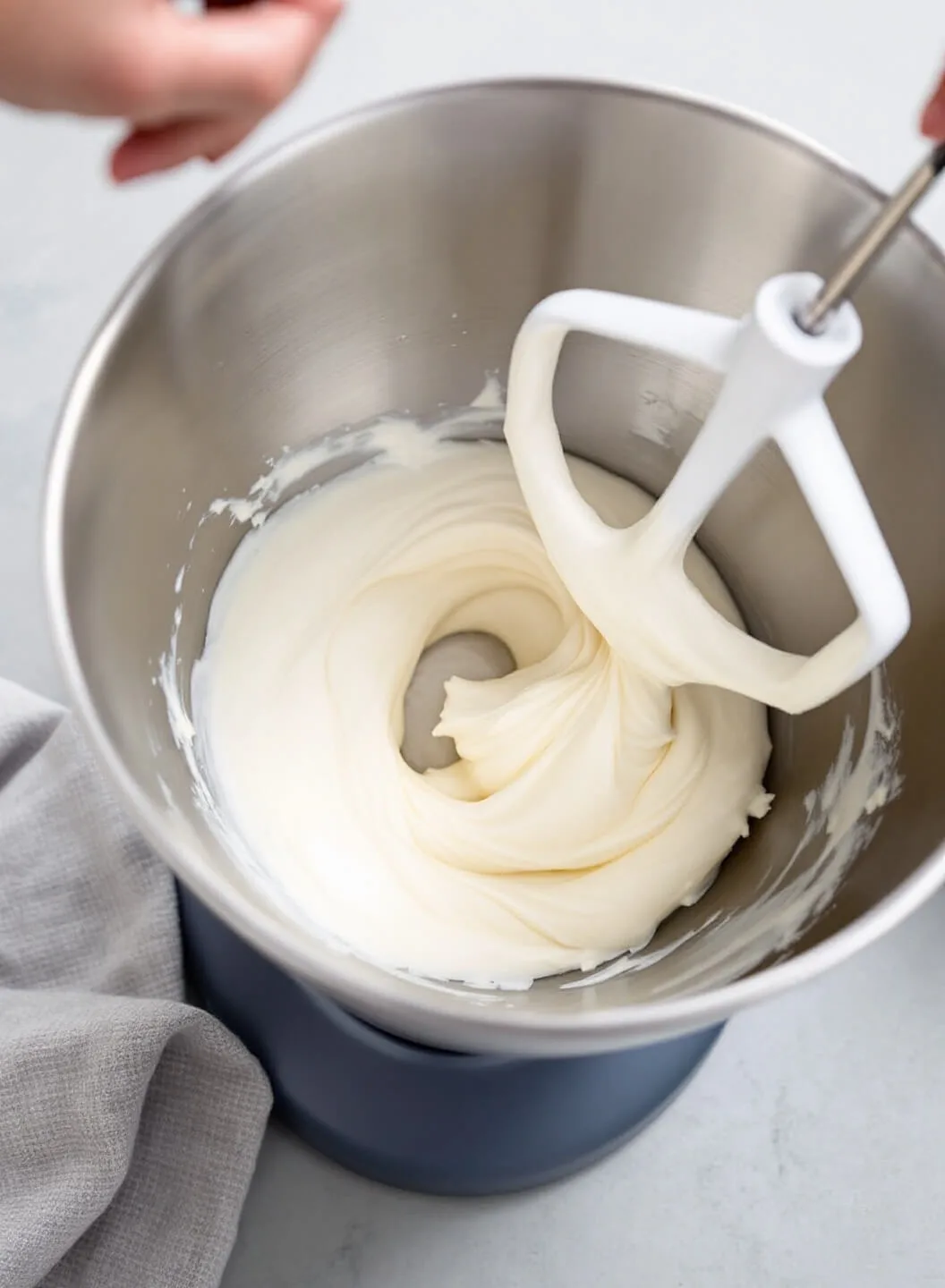 Keto New York Cheesecake With Almond Flour Crust 4 Professional kitchen setup with smooth white cream cheese being mixed in a stainless steel bowl
