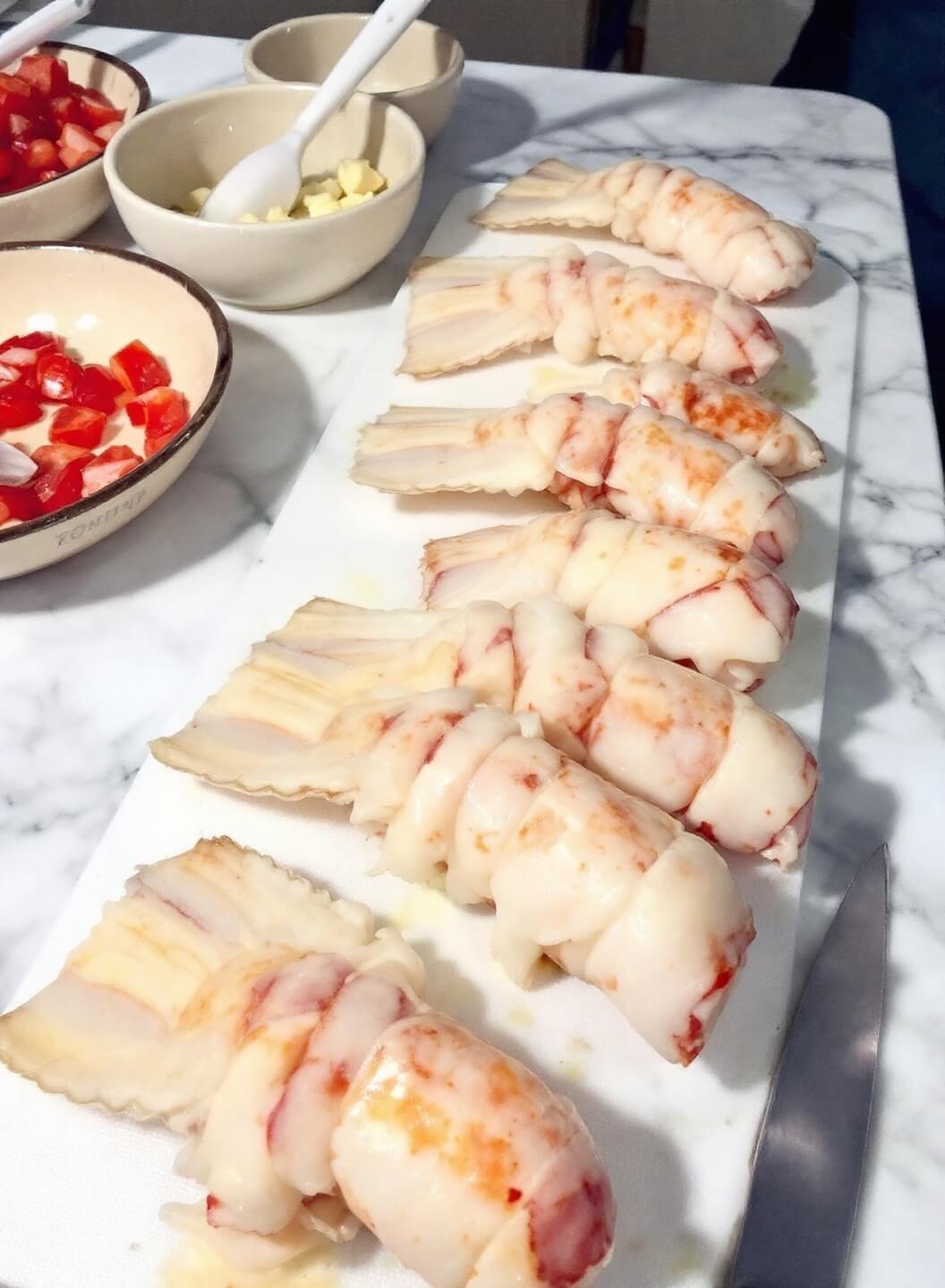 Creamy Keto Lobster Bisque 3 Raw lobster tails being prepped on a marble counter