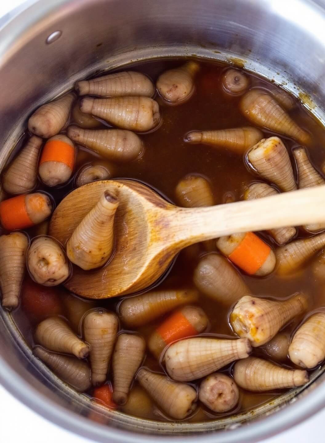 Creamy Keto Lobster Bisque 5 Simmering seafood stock being reduced with wine in a cooking pot.