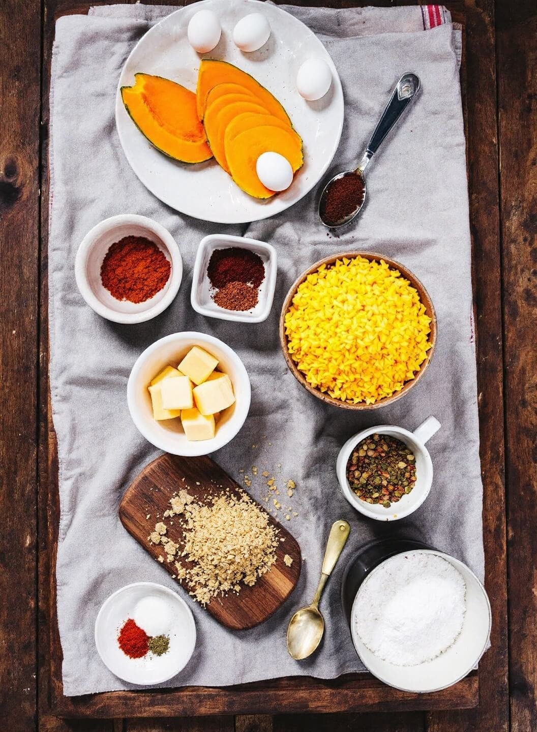 Sugar-Free Sweet Potato Casserole Using Mashed Pumpkin 3 Raw ingredients including pumpkin, eggs and spices displayed on a rustic wooden table