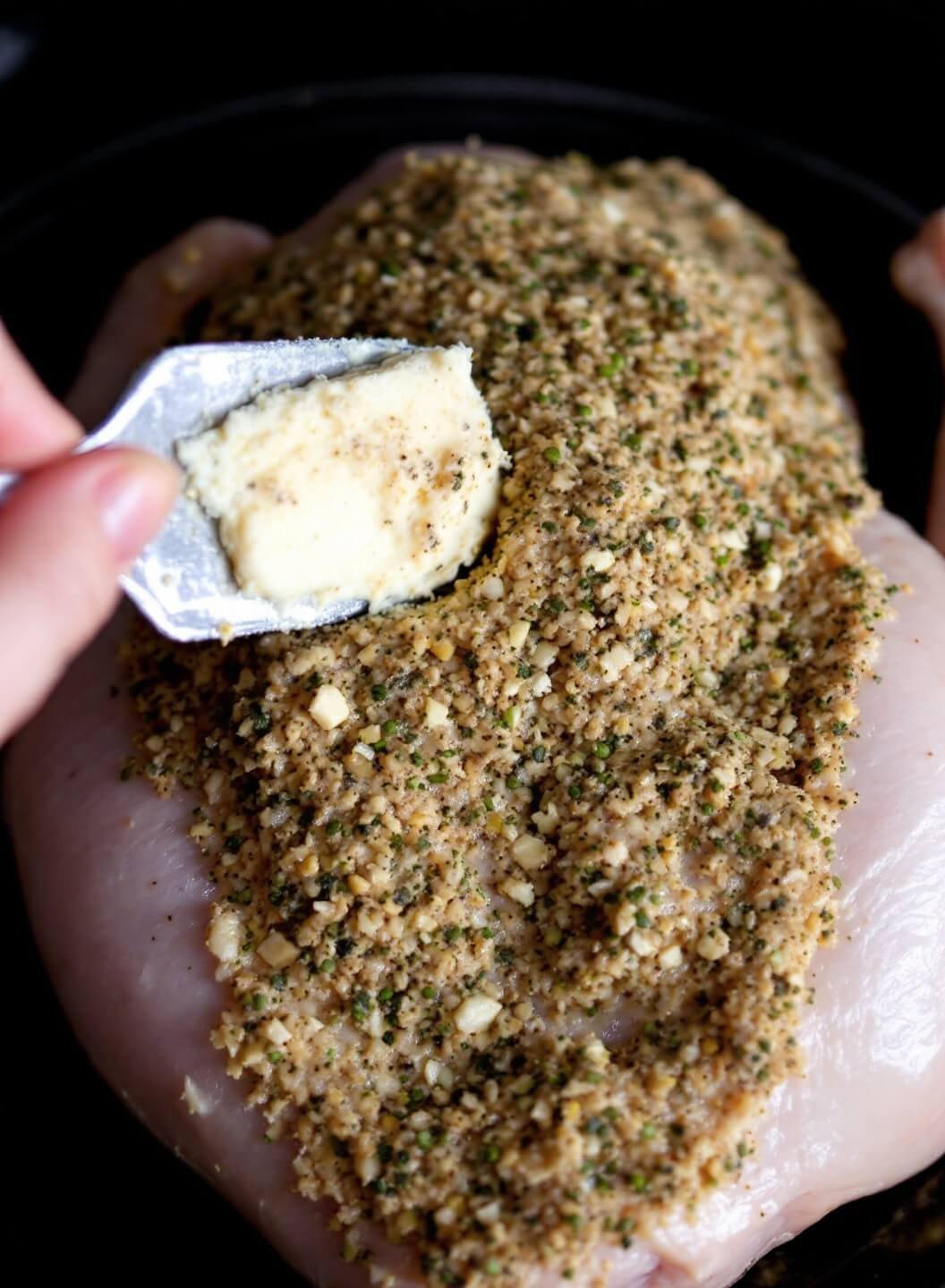 Lemon Garlic Herb Roasted Chicken 4 Close-up image of butter herb mixture being spread under chicken skin