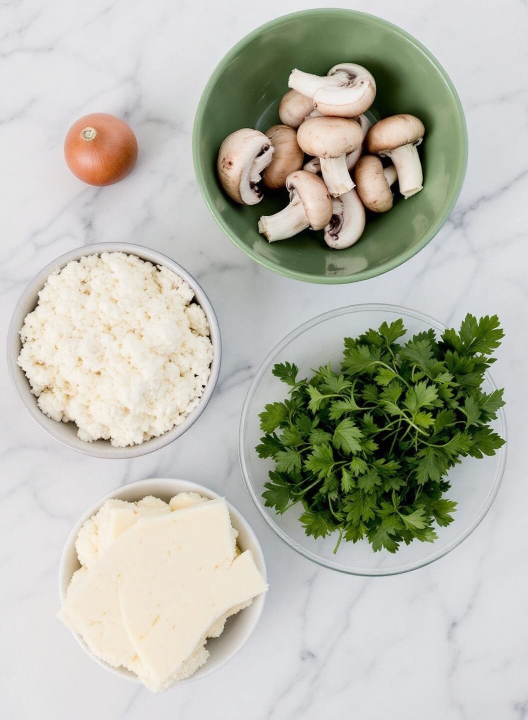 Creamy Mushroom Cauliflower Risotto 3 Assortment of fresh mushrooms, cauliflower, parmesan and herbs on a marble countertop.