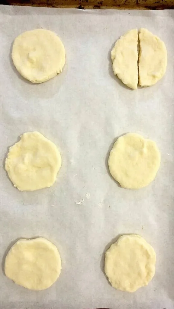 Perfect Keto Biscuits: Fluffy, Buttery, And Just 2G Net Carbs! 5 Portioned raw biscuit dough evenly spaced on a parchment lined baking sheet