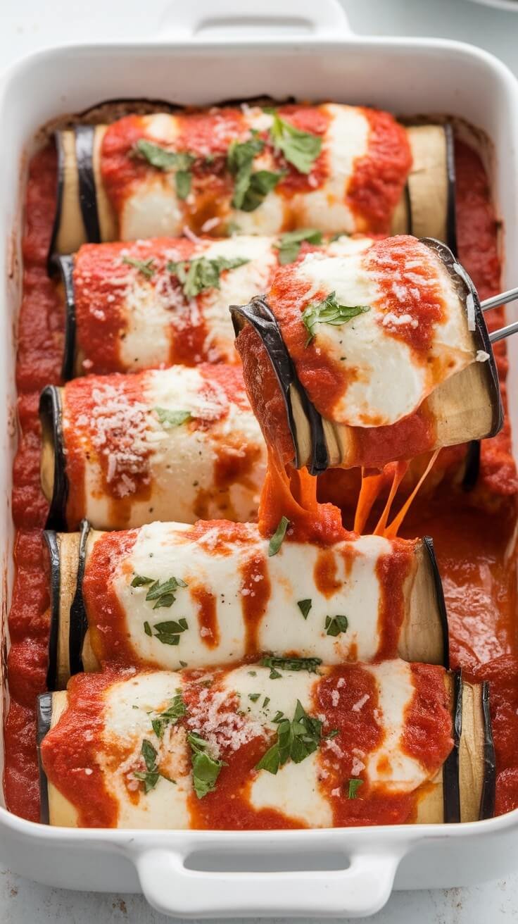 Baking dish filled with eggplant rollatini topped with marinara sauce and cheese.